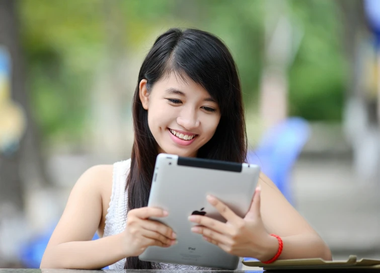 a woman sitting at a table looking at a tablet, pixabay, tachisme, young cute wan asian face, huge smile, outside, teenager girl