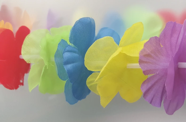 a close up of a bunch of flowers on a string, 58mm, sheer fabrics, fluorescent colours, hawaii