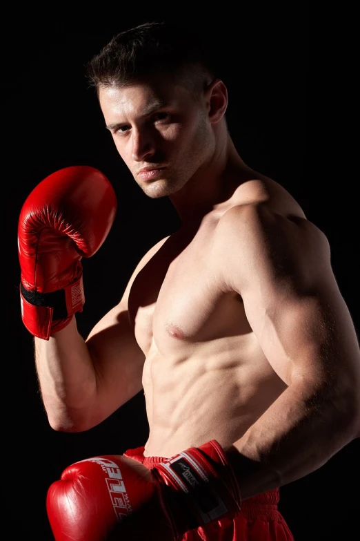 a shirtless man wearing red boxing gloves, a stock photo, by Kazimierz Wojniakowski, shutterstock, fine art, well lit professional photo, young man with medium - length, high quality fantasy stock photo