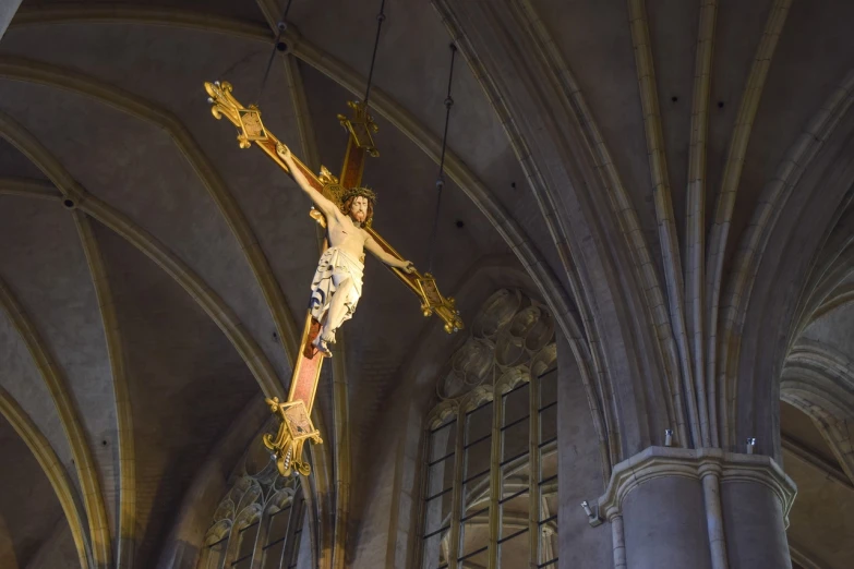 a statue of jesus hanging from the ceiling of a church, a picture, by Simon de Vlieger, high res photo, crosses, flanders, mid shot photo