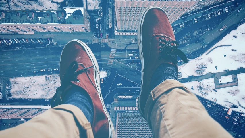 a person standing on top of a tall building, a picture, by Matt Stewart, shoes, hipster, amazing wallpaper, colored photo