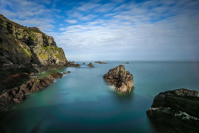 a body of water that has some rocks in it, by Andrew Geddes, cornwall, ultra wide 1 0 mm, picton blue, mundy