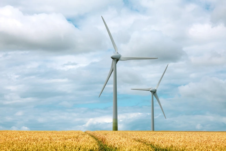 three wind turbines in a wheat field on a cloudy day, a stock photo, shutterstock, more details, very high resolution, unusual composition, on ground