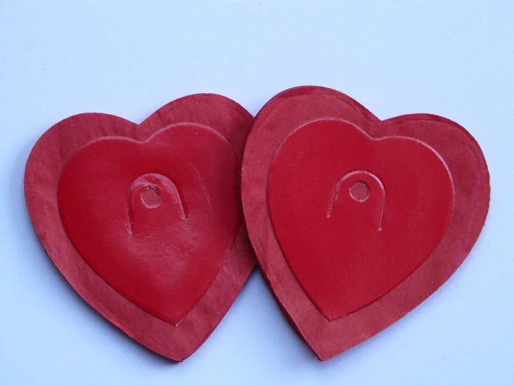 a couple of red hearts sitting next to each other, inspired by Jim Dine, hurufiyya, medallions, instructions, latex, back - view