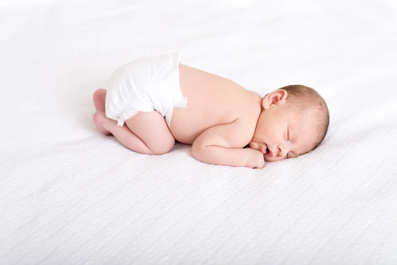 a baby in a diaper sleeping on a bed, a stock photo, by Juan O'Gorman, shutterstock, white backdrop, smooth textured skin, hip and leg shot, high resolution!!