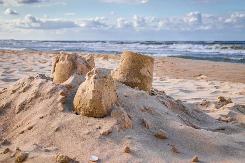 a pile of sand sitting on top of a sandy beach, a stock photo, shutterstock, fine art, castle towers, built around ocean, usa-sep 20, mortar heads