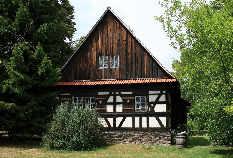 a brown and white house surrounded by trees, a picture, by Karl Hagedorn, shutterstock, heidelberg school, medieval cottage interior, black house, modern rustic, half length shot