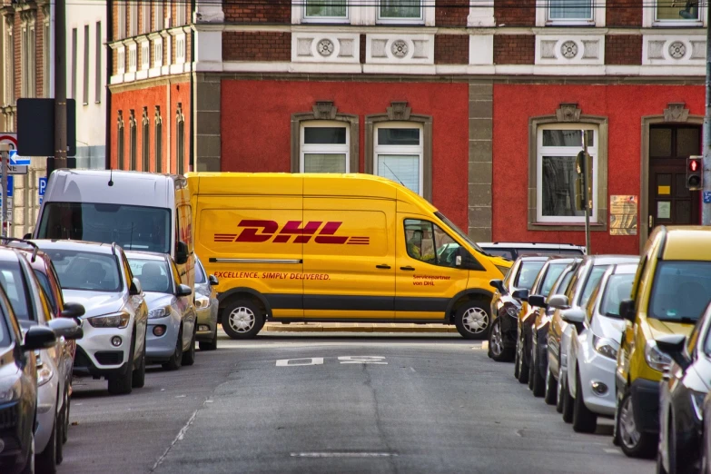 a yellow dhl van parked on the side of a street, by Derek Hill, shutterstock, photorealism, 🦩🪐🐞👩🏻🦳, broad daylight, f 2. 8 3 5 mm, mann