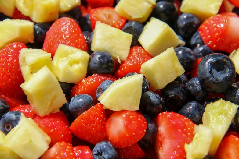 a close up of a fruit salad with pineapples, strawberries, and blueberries, by Paul Emmert, pexels, renaissance, 🦩🪐🐞👩🏻🦳, closeup 4k, juice, cheesy