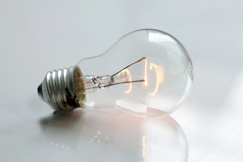 a light bulb sitting on top of a table, a picture, crisp and clear, molten, fully functional, light bends to it