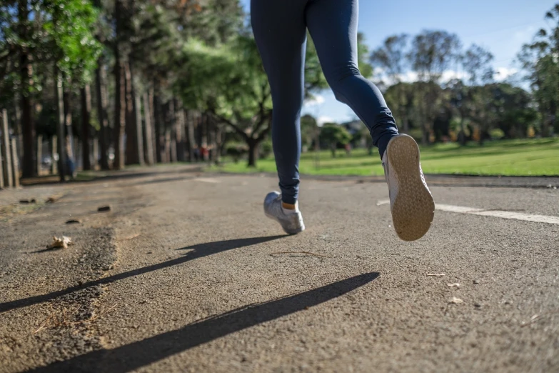 a person running on a road with trees in the background, shutterstock, realism, detailed shot legs-up, with a park in the background, lowres, performing