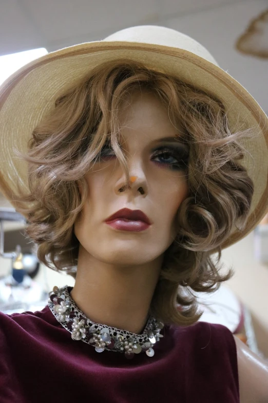 a close up of a mannequin wearing a hat, a portrait, art nouveau, curly middle part haircut, accompany cory chase, shag cut, 60s style