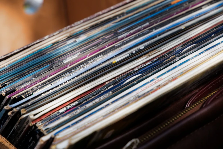 a pile of vinyl records sitting on top of a wooden table, an album cover, by Jakob Gauermann, shutterstock, rack focus, stock photo, comic books, close-up photo