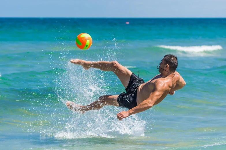 a man flying through the air while playing with a ball, a stock photo, by Ivan Grohar, shutterstock, fine art, waves and splashes, the emerald coast, very sweaty, usa-sep 20