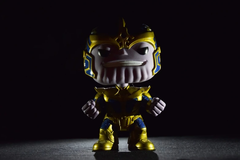 a close up of a toy in the dark, unsplash, thanos style traits, as a full body funko pop!, “ golden chalice, scary angry pose