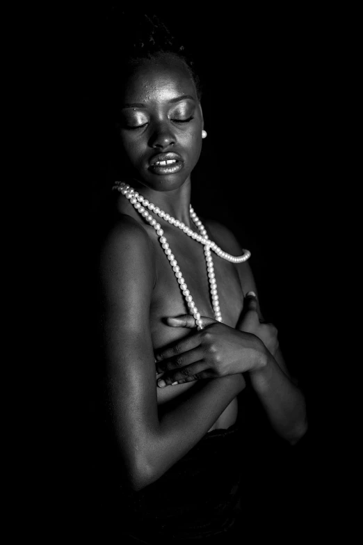 a black and white photo of a woman in pearls, featured on cgsociety, dark skin female goddess of love, calvin klein photography, beads cross onbare chest, in style of caravaggio