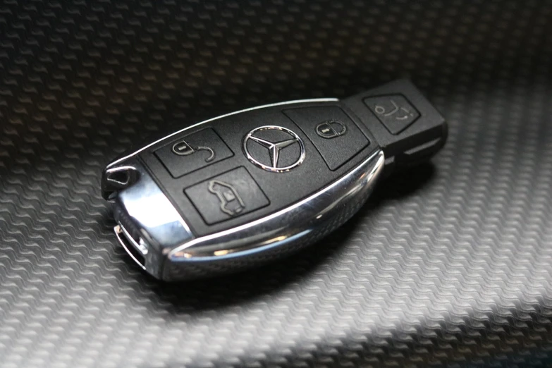 a mercedes key case sitting on top of a car seat, an engraving, happening, highly detailed product photo, hyper realistic ”