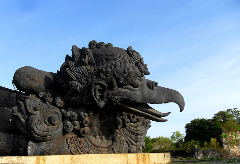 a close up of a statue with a bird on it's head, a statue, by I Ketut Soki, flickr, sumatraism, cloud in the shape of a dragon, head of an eagle, powerful and huge, black