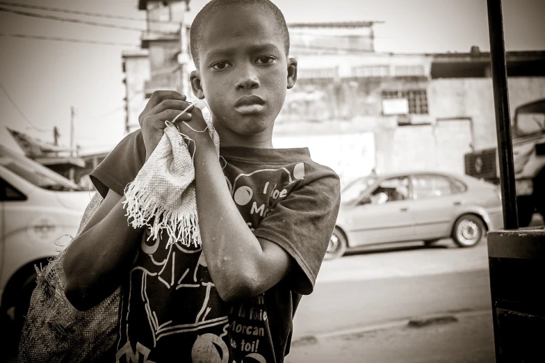 a black and white photo of a young boy talking on a cell phone, by Joze Ciuha, flickr, sao paulo, tattered clothes, ! holding in his hand !, portrait of small