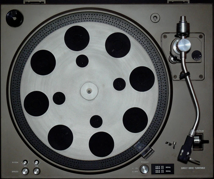 a close up of a record player's turntable, by Ottó Baditz, flickr, pop art, black dots, cinemascope panorama, white with black spots, taken in the early 1990s