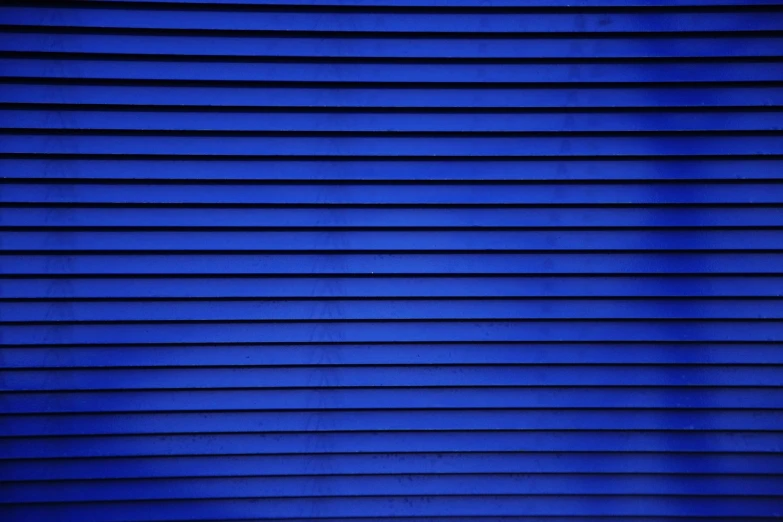 a red fire hydrant sitting in front of a blue wall, inspired by Andreas Gursky, postminimalism, soft light through blinds, cobalt blue, 4k (blue)!!, metal cladding wall