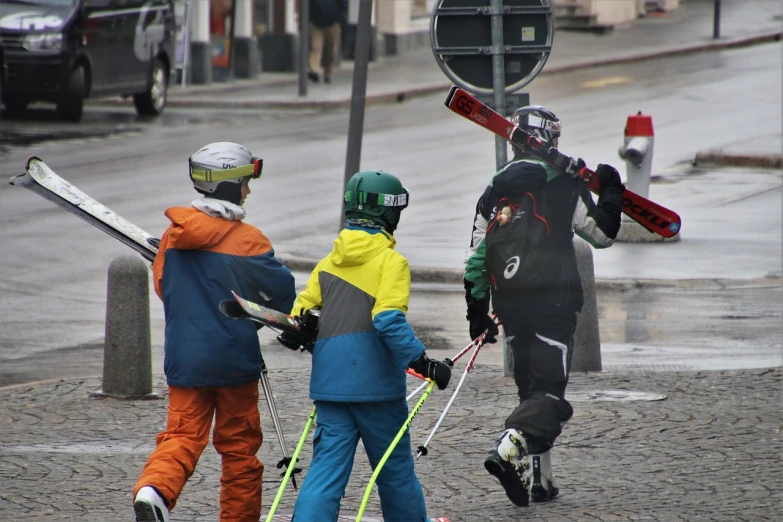 a group of people walking across a street holding skis, by Ejnar Nielsen, flickr, overcast!!!, kids playing, action sports, tallinn