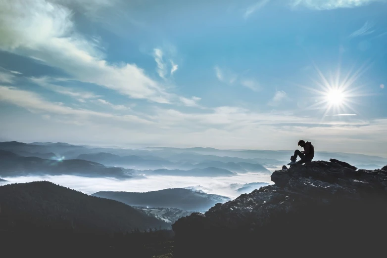 a person sitting on top of a mountain, romanticism, above low layered clouds, overlooking a valley, photo taken with provia, sharp focus on scenery