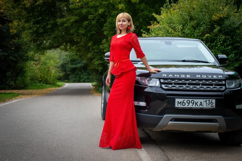 a woman in a red dress standing next to a car, a portrait, by Alexander Fedosav, pixabay contest winner, ukraine. professional photo, on a mannequin. high resolution, dressed in long fluent skirt, dressed in a lacy