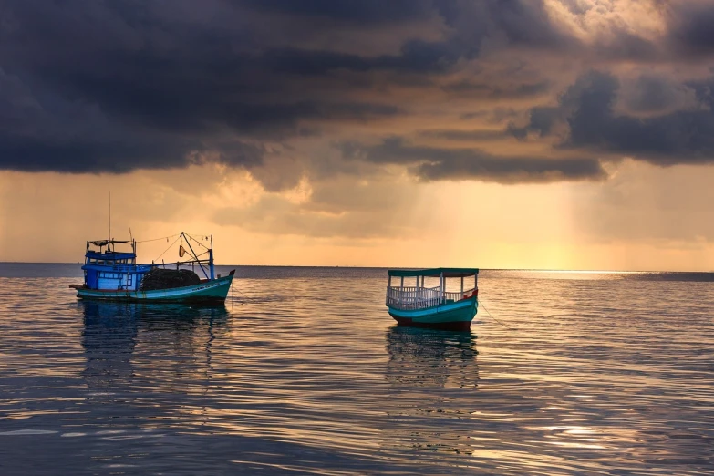 a couple of boats floating on top of a body of water, a picture, by January Suchodolski, shutterstock, sumatraism, evening storm, egypt, stock image, calm sea