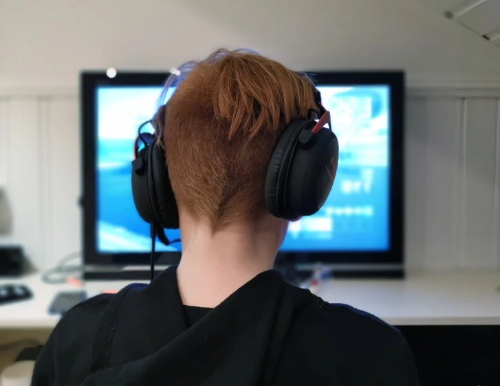 a person sitting in front of a tv wearing headphones, a picture, pc game, red haired teen boy, pictured from the shoulders up, close-up shot taken from behind