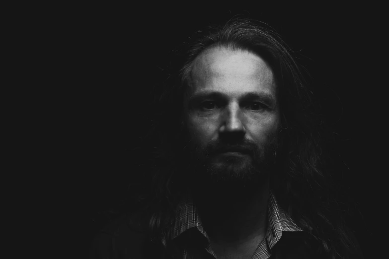 a black and white photo of a man with long hair, by Matthias Weischer, lofi portrait, low key light, bearded man, arthouse. y greg rutkowski