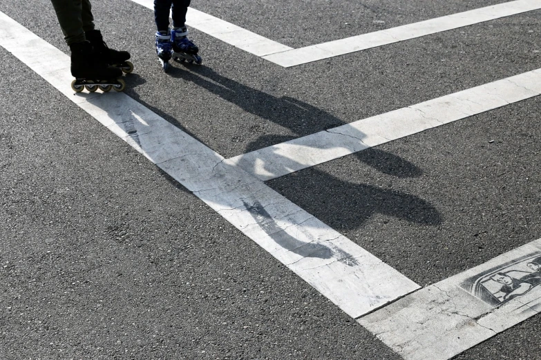 a person riding a skateboard across a crosswalk, by Kiyoshi Yamashita, flickr, people's silhouettes close up, cross hatched, siblings, ! low contrast!