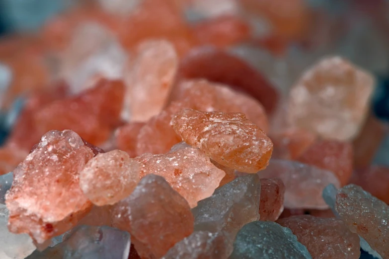 a pile of sugar crystals sitting on top of a table, a macro photograph, by Emanuel Büchel, pexels, pink and teal and orange, sandy colors, seaglass, soft red texture