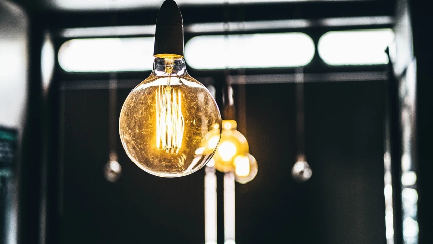 a group of light bulbs hanging from a ceiling, a picture, by Jesper Knudsen, pexels, light and space, warm yellow lighting, an upright lightbulb, istock, wide screenshot