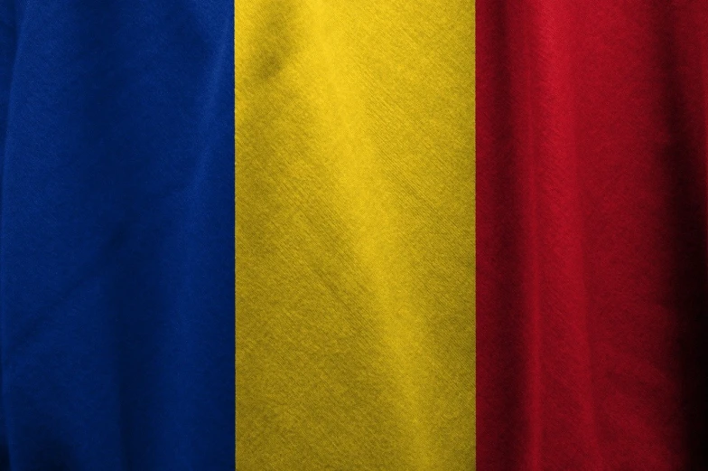 a close up of a red, yellow and blue shirt, inspired by Ștefan Luchian, shutterstock, flag, cotton texture, transylvania, background made of big curtains