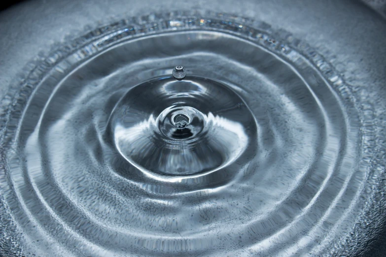 a black and white photo of a water drop, renaissance, rippling electromagnetic, highly detailed product photo