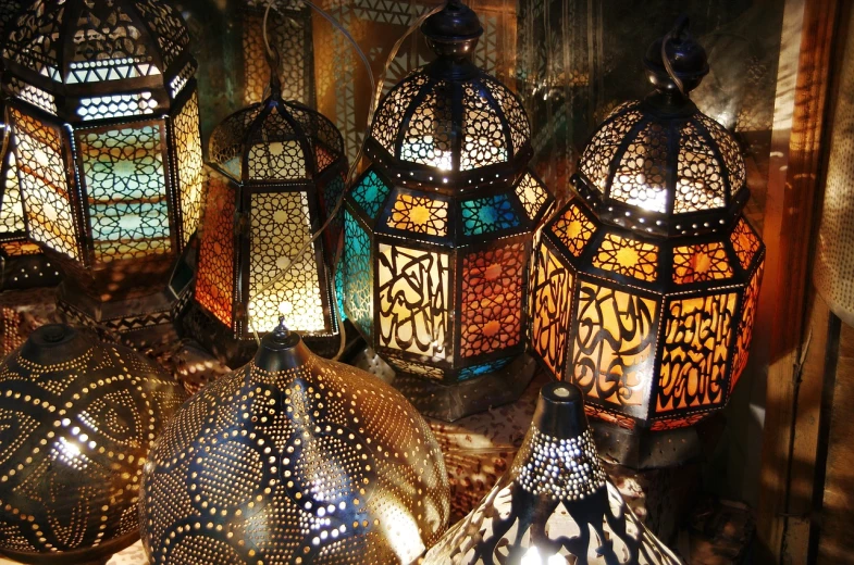 a group of lamps sitting on top of a table, egyptian art, shutterstock, arabesque, shiny colors, intricate ”, great light and shadows”, (((intricate)))