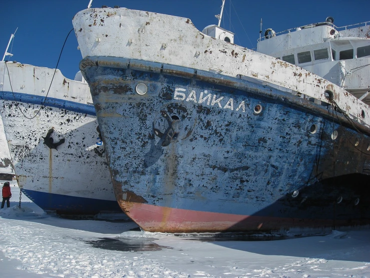 a couple of boats that are sitting in the snow, inspired by Vladimir Borovikovsky, flickr, graffiti, he is covered with barnacles, baraka, tourist photo, low quality photo