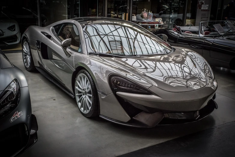 a silver sports car parked in a garage, by Raphaël Collin, pexels contest winner, purism, mclaren, glazed, very very happy!, los angeles 2 0 1 5