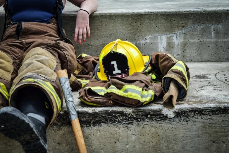 a firefighter's gear sits on the steps of a building, a photo, by Christen Dalsgaard, pexels, 1 female, costume, in an arena pit, seattle
