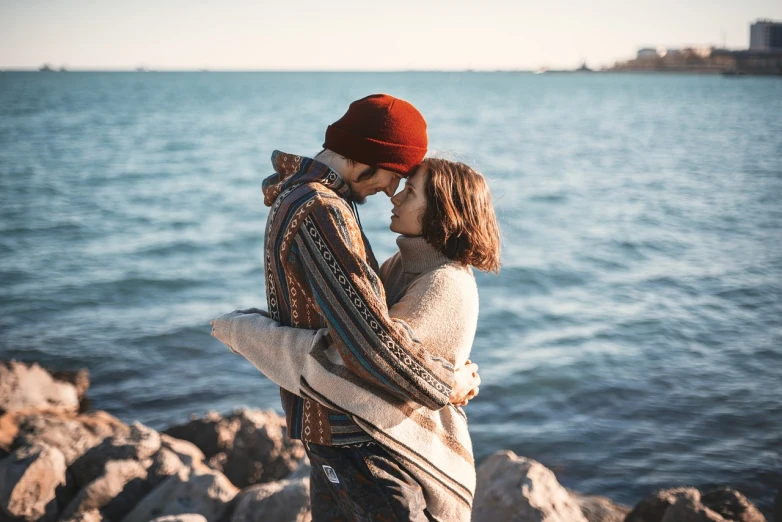 a man and woman standing next to each other near a body of water, a picture, pexels, romanticism, hugging and cradling, attractive girl, 1 1 1 1, peasant boy and girl first kiss