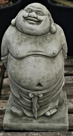 a statue of a laughing buddha sitting on a table, a statue, inspired by Shūbun Tenshō, concrete art, closeup - view, fat belly, 155 cm tall, david normal