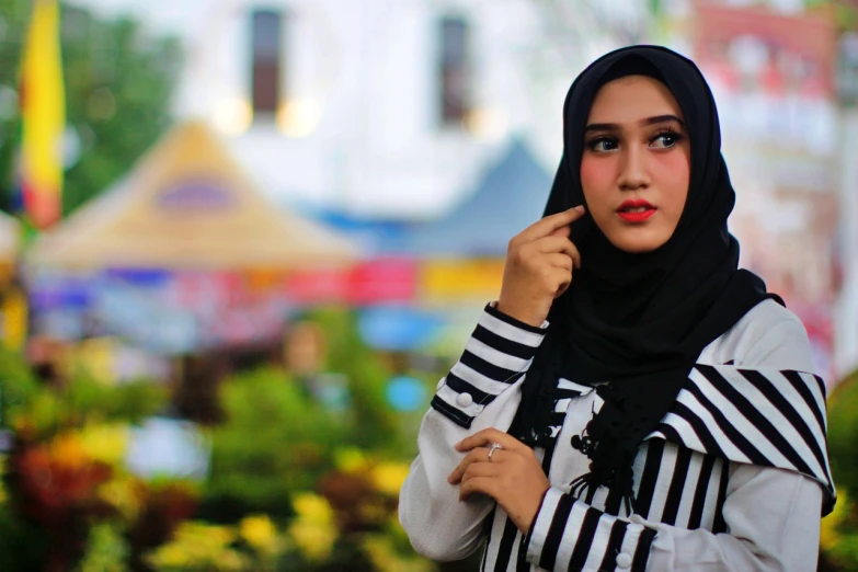 a woman wearing a black and white striped scarf, a picture, inspired by Fathi Hassan, shutterstock, cute girls, innocent look. rich vivid colors, white hijab, square