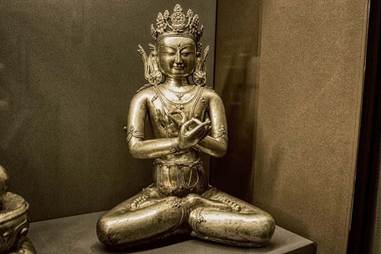 a statue of a person sitting on a table, a statue, cloisonnism, anjali mudra, metropolitan museum photo, sepia tone, aura of power. detailed