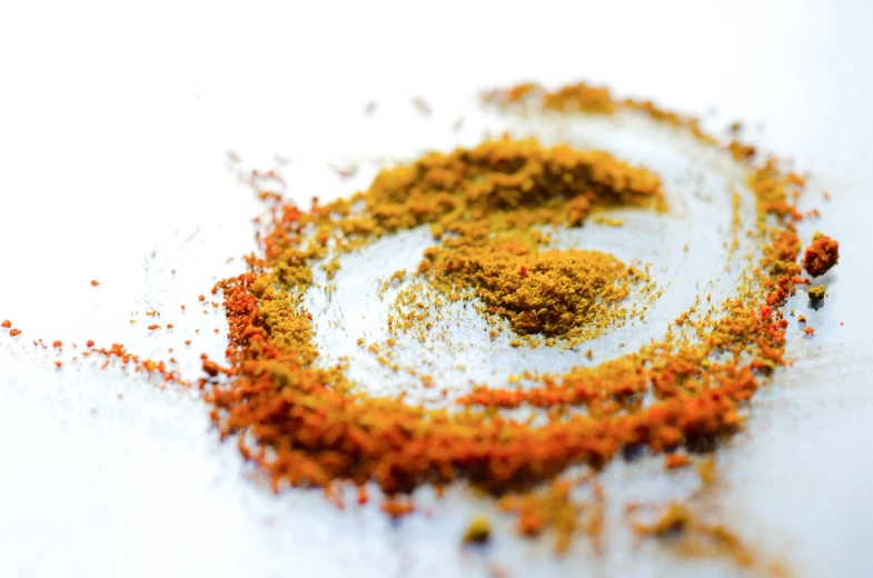 a pile of spices sitting on top of a table, a macro photograph, by Thomas Häfner, pexels, hurufiyya, magic powder, on a white background, sacral chakra, orange yellow ethereal