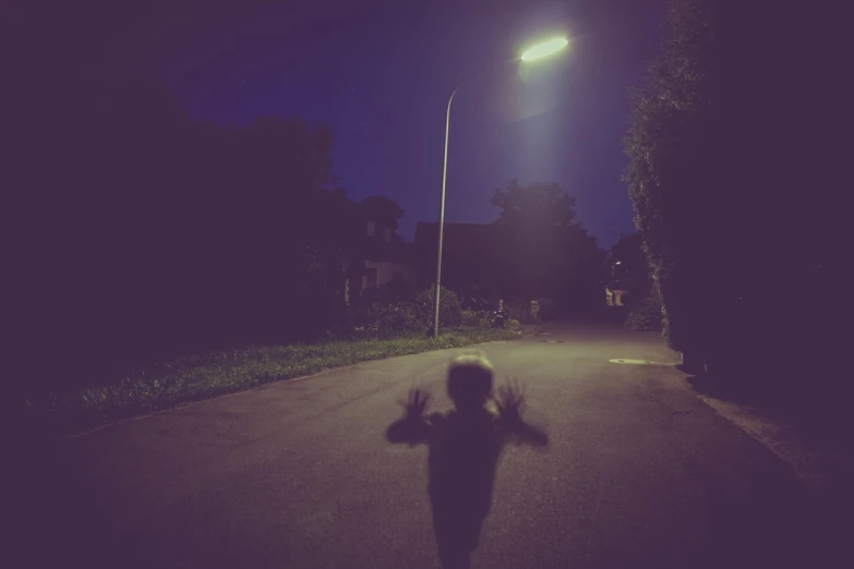 a person riding a skateboard down a street at night, a picture, postminimalism, creepy child, with arms up, little kid, single image