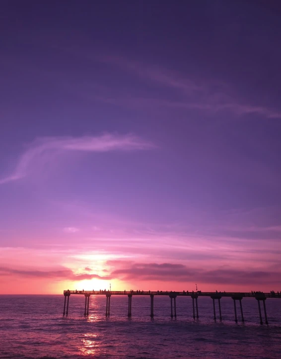 a pier in the middle of the ocean at sunset, by Robbie Trevino, romanticism, gradient purple, timelapse, 33mm photo