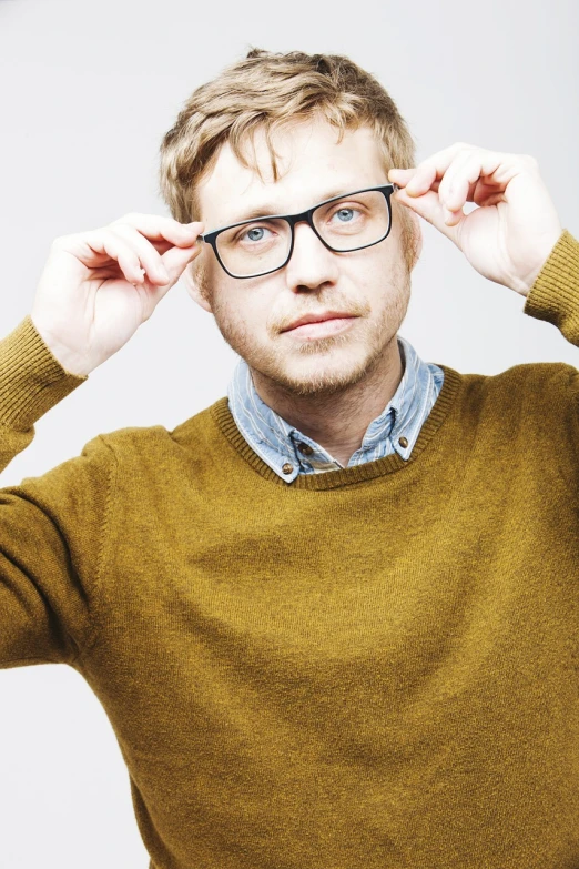 a close up of a person wearing glasses, a picture, by Jóhannes Sveinsson Kjarval, shutterstock, wearing casual sweater, one man is blond, joe pera, young man with medium - length