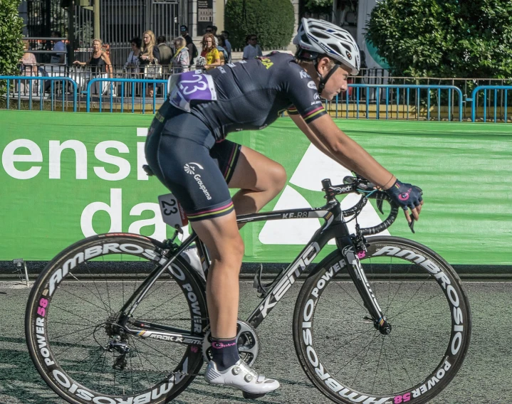 a man riding a bike down a street, a photo, inspired by Nagasawa Rosetsu, dribble, side view of her taking steps, in a race competition, toni infante, confident pose