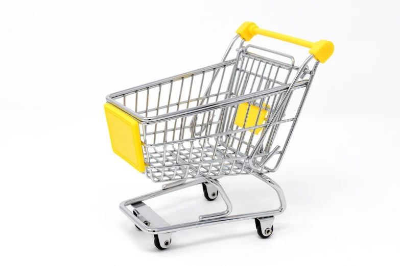 a miniature shopping cart on a white surface, a picture, aoshima, silver and yellow color scheme, high res photo, shops